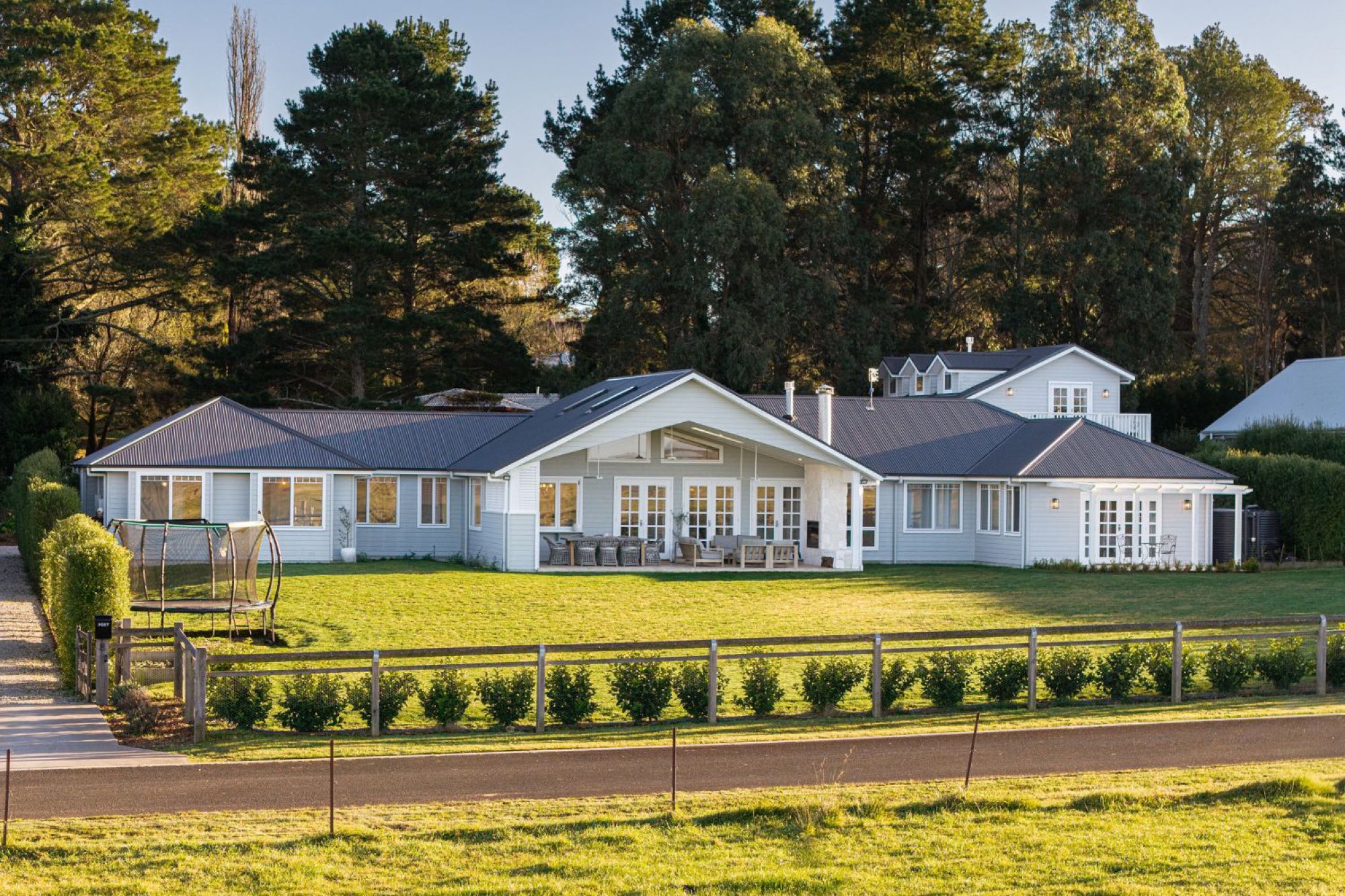 Birchgrove across the lawn in afternoon light, the terrace set with table and chairs.